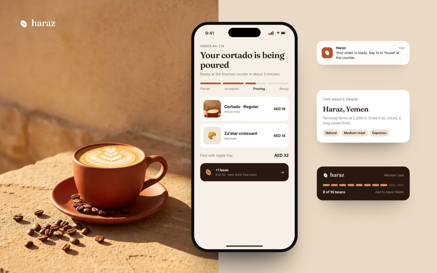 A cortado on warm stone beside the Haraz order-tracking screen and loyalty card